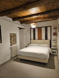 a bedroom with a white bed and a wooden ceiling at Casa Rubini in Paestum