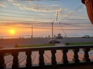 a view of the beach from a balcony with the sunset at Julia house in Huanchaco