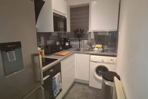 a kitchen with a washing machine and a washer at Top Hat Luton flat free parking in Luton +2 photos