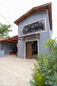 ein Haus mit einem großen Fenster an der Seite in der Unterkunft Rec. Harmonia Wi-Fi Piscina Churrasqueira Lareira in Juquitiba