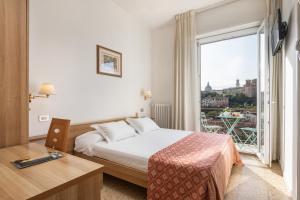 a hotel room with a bed and a large window at Hotel Minerva in Siena