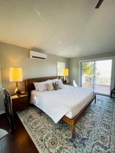 een slaapkamer met een groot bed en een groot raam bij Finn's Hideaway -Modern family river home in Keokuk