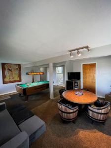 een woonkamer met een tafel en een pooltafel bij Finn's Hideaway -Modern family river home in Keokuk