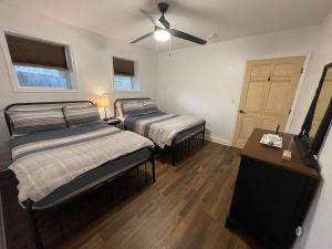 2 camas num quarto com uma ventoinha de tecto em Don Quixote Lakefront log cabin em Eufaula