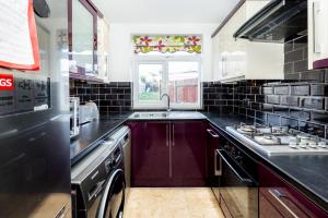 a kitchen with a sink and a stove at Gardened 2BR house, quiet Cul-de-Sac of Wembley in Preston