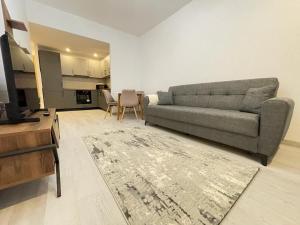 YamaLuxe Apartments - Silent & Primitive With Relaxing Area في بوخارست: غرفة معيشة مع أريكة وطاولة