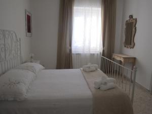 una camera da letto con un letto bianco e asciugamani di Welcome to Alberobello ad Alberobello