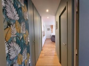 a hallway with a mural of leaves on a wall at Le Richelieu "Côté sud" Appartement 302 in La Bourboule