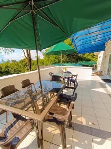 - une table et des chaises avec des parasols verts sur la terrasse dans l'établissement Finca vacacional en Melgar - Capacidad max. 26, à Melgar