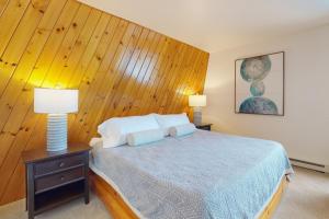 a bedroom with a bed with a wooden wall at Pokey Moonshine in Springwater