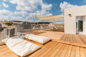 balkon z 2 poduszkami na drewnianym tarasie w obiekcie Terrazza Dei Sogni w mieście Ragusa