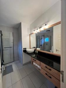 a bathroom with a sink and a mirror at Cosy suite in the heart of Ebene in Quatre Bornes