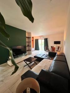 a living room with a couch and a flat screen tv at Cosy suite in the heart of Ebene in Quatre Bornes