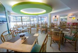 a restaurant with tables and chairs and a green ceiling at Flat Ambassador - Cabo Branco - João Pessoa in João Pessoa