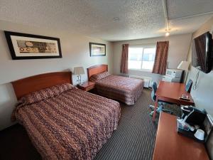 Habitación de hotel con cama y escritorio en Horizon Inn 2 en Valleyview