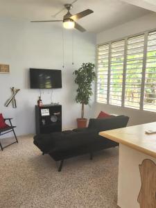 a living room with a couch and a flat screen tv at Beautiful House With Gazeebo Close to Beach in Ceiba