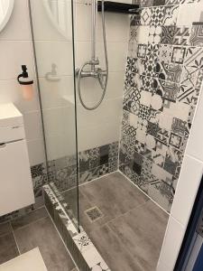 a shower in a bathroom with mosaic tiles at Cazare Poiana in Braşov