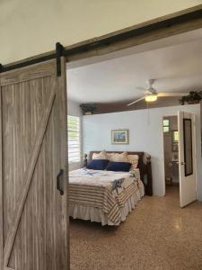 a sliding barn door in a bedroom with a bed at Beautiful House With Gazeebo Close to Beach in Ceiba