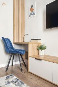 a living room with a blue chair and a tv at Cazare Poiana in Braşov