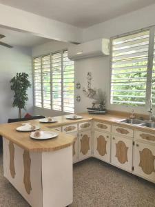 a kitchen with white cabinets and a wooden counter top at Beautiful House With Gazeebo Close to Beach in Ceiba