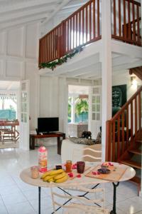 een woonkamer met een tafel met bananen erop bij La Petite Villa Guadeloupe in Sainte-Anne