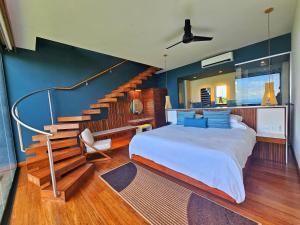 a bedroom with a large bed and a staircase at Los Altos Resort in Manuel Antonio