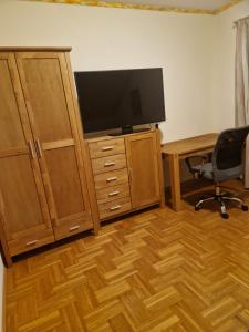 Zimmer mit einem Schreibtisch mit einem TV und einem Schreibtisch sidx sidx sidx. in der Unterkunft Ferienwohnung am Stadtrand in Sankt Pölten