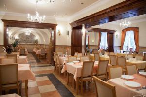 a restaurant with tables and chairs and a chandelier at Zameczek in Kudowa-Zdrój