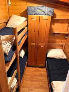 Zimmer mit 3 Etagenbetten in einer Hütte in der Unterkunft Sunwaychalets Lago di Lugano in Porlezza