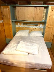 ein großes Bett in einem Zimmer mit Holzschränken in der Unterkunft Sunwaychalets Lago di Lugano in Porlezza