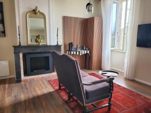 a living room with a chair and a fireplace at Domaine de la Gémolière in Gémozac
