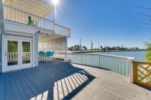a house with a deck with a view of the water at Waterfront Haven Padre Island Home with Swim Spa! in Padre Island
