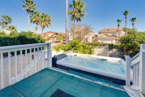 a hot tub on a balcony with palm trees at Waterfront Haven Padre Island Home with Swim Spa! in Padre Island