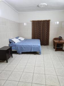 a bedroom with a bed and a tiled floor at Osu Apartment in Accra