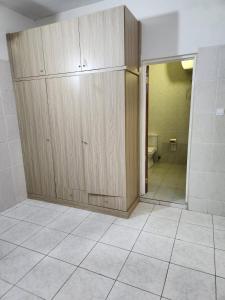 ein Badezimmer mit einem großen Holzschrank und einem WC in der Unterkunft Osu Apartment in Accra