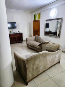 ein Wohnzimmer mit einem Sofa und einem Stuhl in der Unterkunft Osu Apartment in Accra