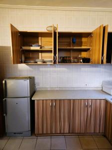 a kitchen with wooden cabinets and a refrigerator at Osu Apartment in Accra