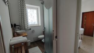 a bathroom with a toilet and a sink and a window at Welcome to Alberobello in Alberobello