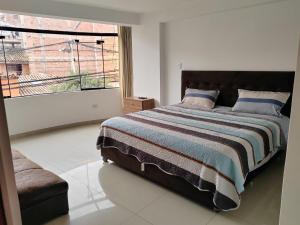 een slaapkamer met een groot bed en een groot raam bij Pacheco APARTMENT in Cuzco