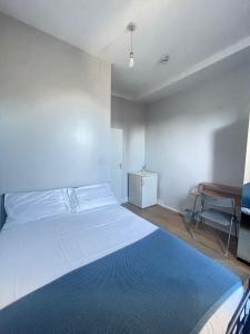 a bedroom with a large bed and a desk at Dalston's Rooms in London