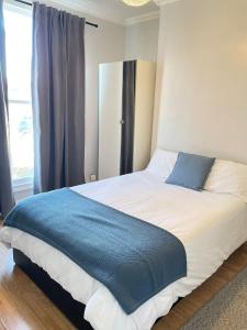 a bedroom with a large bed with a blue blanket at Dalston's Rooms in London