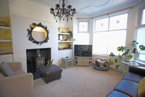 a living room with a blue couch and a fireplace at Spacious and bright 4 bed home in vibrant Chorlton in Manchester