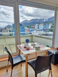 a table and chairs in a room with a large window at Lo de Moli 5A in Ushuaia