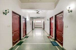 an empty corridor with brown doors in a building at J C Guest House in Hasanganj