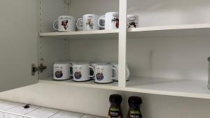 eine Reihe Kaffeetassen auf Regalen in einer Küche in der Unterkunft Moderne Appartement in Nürnberg
