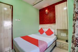 a bedroom with a bed with red and white pillows at OYO 67027 Grace Inn in Mumbai