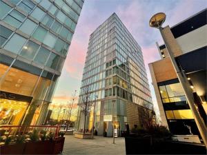 un edificio de cristal alto frente a un edificio en Luxury Milton Keynes Apartment at The Prevé en Milton Keynes