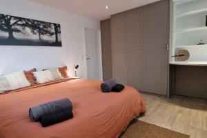 um quarto com uma cama grande e um cobertor laranja em La Fauvette em Embourg