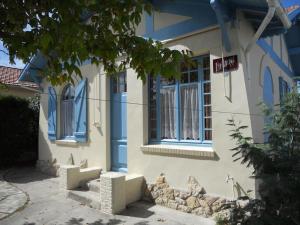 a blue and white house with a window at Villa proche centre et plage - V04245 in Soulac-sur-Mer