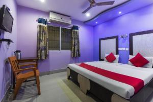 een slaapkamer met een groot bed met paarse muren bij Hotel Kohinoor in Durgapur